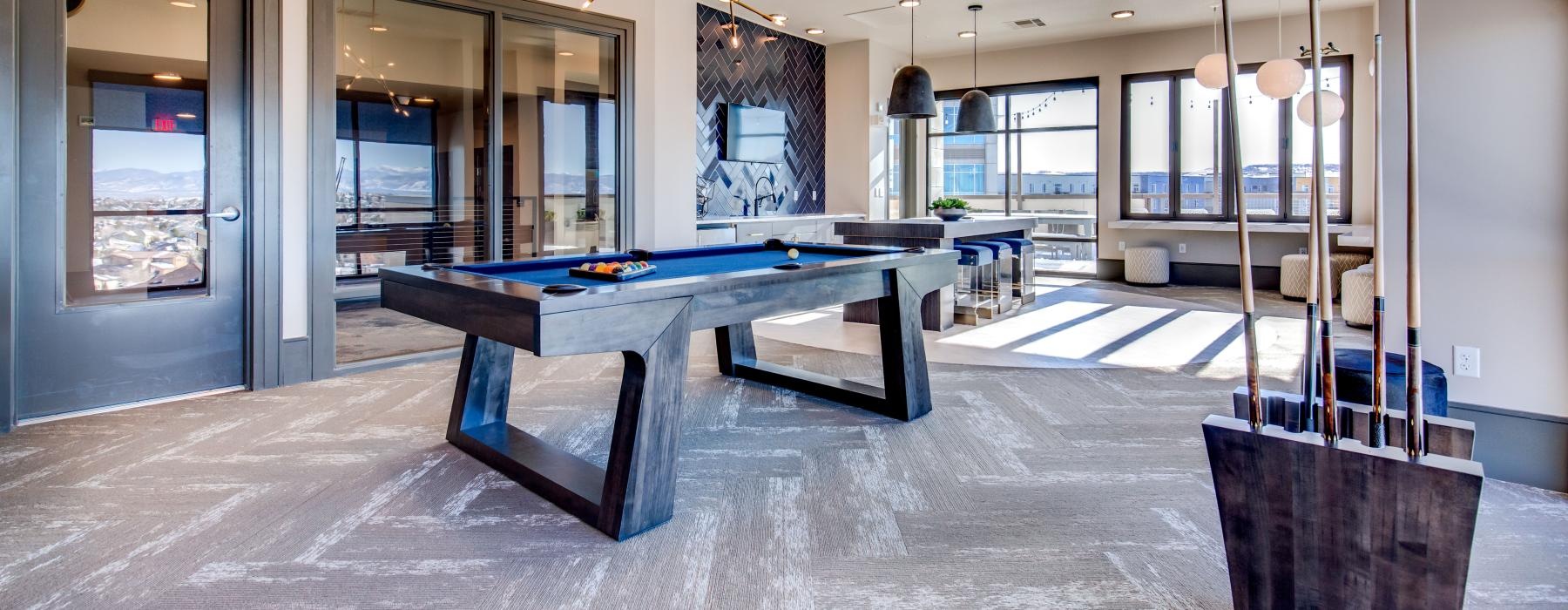 a room with a pool table and chairs